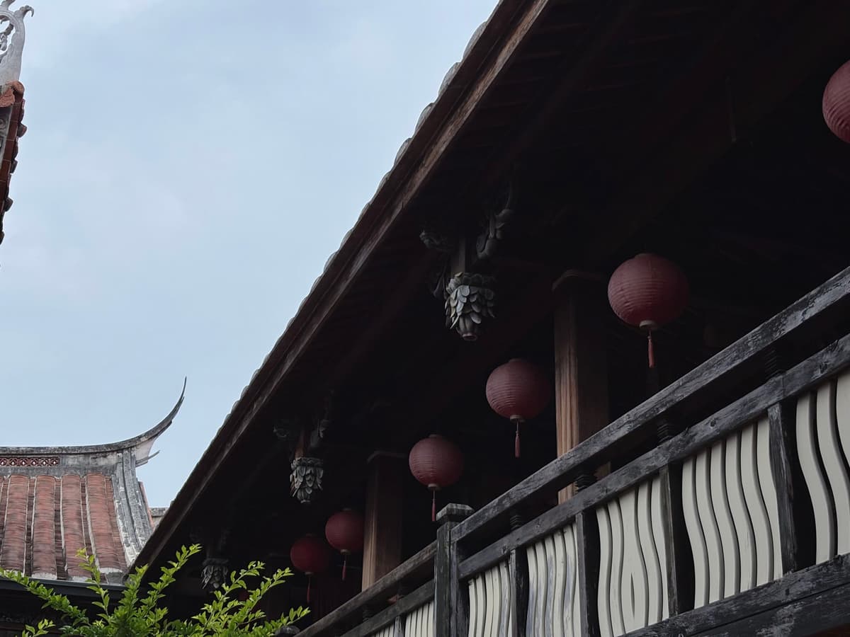 大花廳廊道上一排紅燈籠,屋簷弧線與天空相接