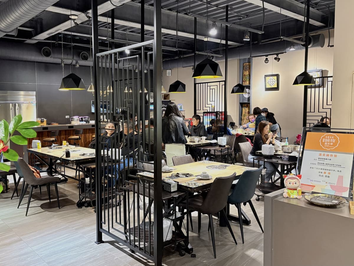 用餐區以黑色鐵件屏風分隔,桌位坐著用餐的客人
