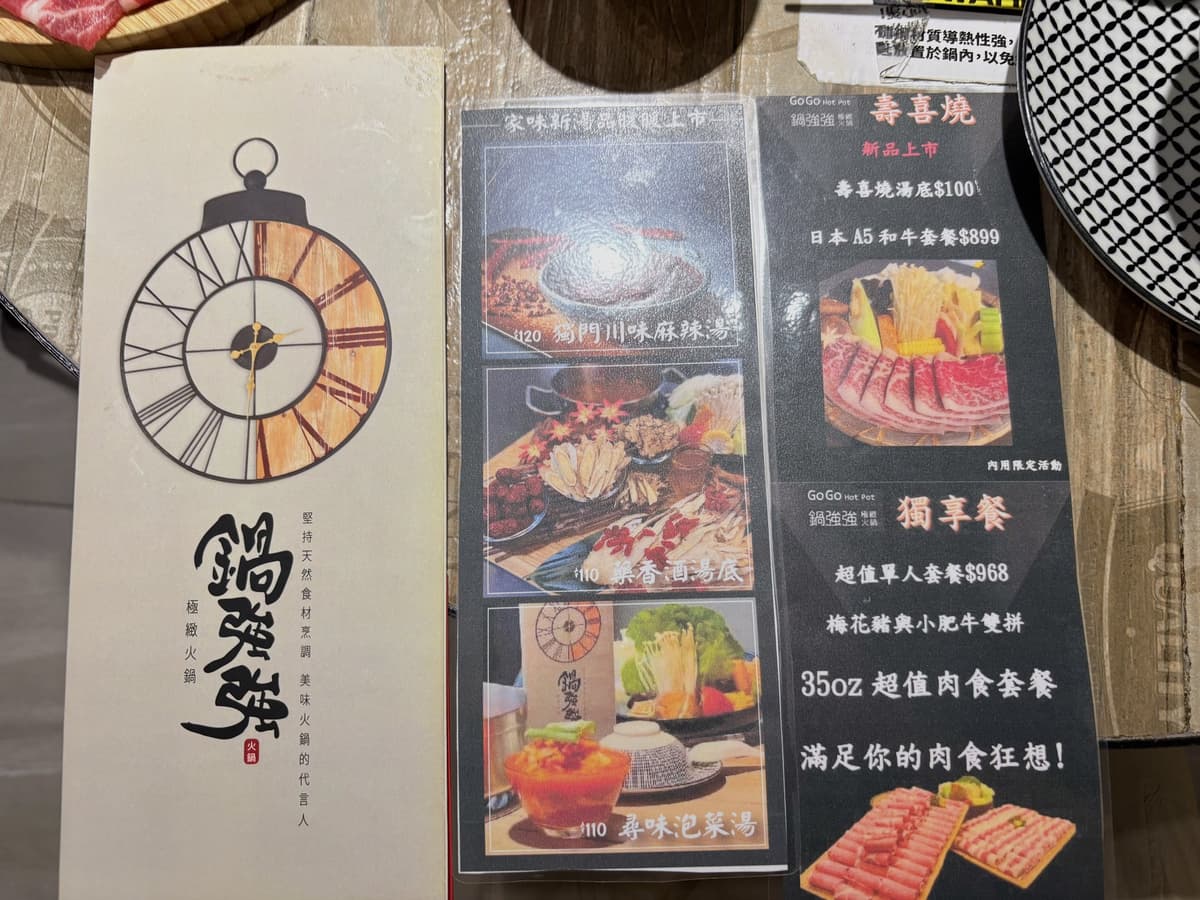 桌上的菜單與壽喜燒、日本 A5 和牛套餐的宣傳立牌