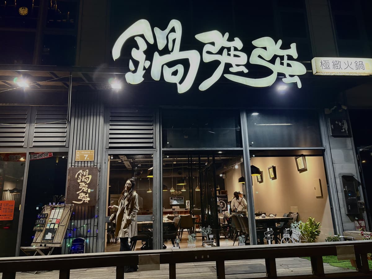 鍋強強的店面外觀,招牌在夜色中亮著