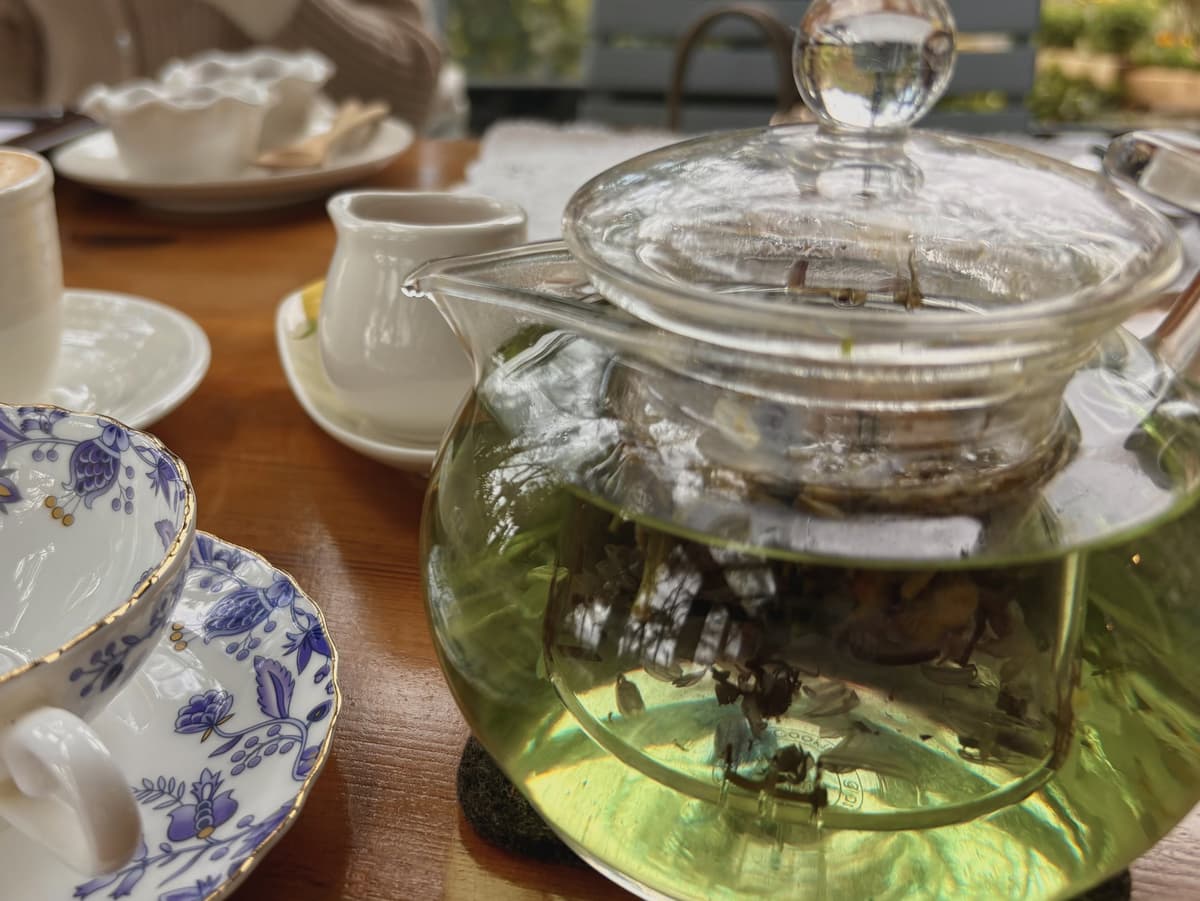 玻璃茶壺裡的花草茶,桌上擺著青花瓷杯組